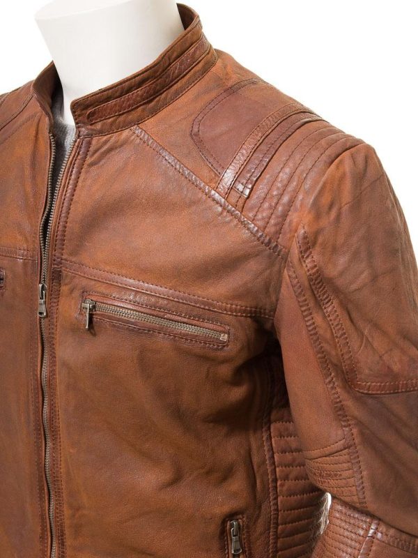A striking tan leather biker jacket with a matte finish. Crafted from sheep aniline leather that has been lightly milled to an aged, matte nubuck finish, this jacket features an exposed YKK zip front that leads up to a short nehru collar. There are four zipped pockets on the body of the jacket plus zipped gauntlet style cuffs, perfect for slipping a thick glove beneath. Extra panels on the collar and shoulder plus ribbed stitch quilting on the side panels contrast the vintage patina of the leather for a truly unique design. The interior of the jacket is fully lined in poplin and includes two more leather trimmed pockets. One of these is zipped and the other buttoned for additional security.